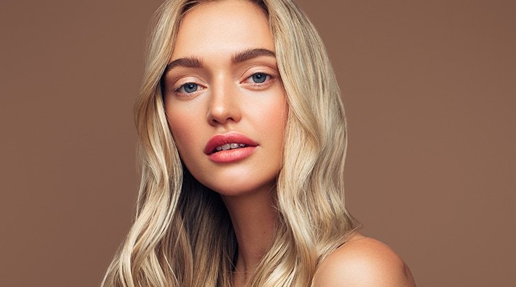 Junge Frau mit langen hellblonden, gewellten Haaren